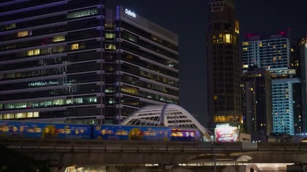 バンコクのチョン ノンシ歩行者橋の高層ビル間のオーバーパスで地下鉄の列車を渡る 2023年12月27日 — ストック動画