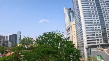 Metropolis şehir merkezindeki yeşil ağaçlar ve yüksek binalar. Yeşil çevre şehri ve panoramik manzaralı şehir merkezi iş bölgesi. Bangkok, Tayland 03 Şubat 2024.