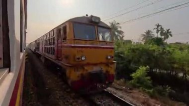 Yolcu vagonlu dizel lokomotif ve kırsal alanda birbirine doğru giden bir tren. Tayland, Bangkok Pattaya, 08 Şubat 2024