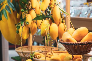 Tropikal meyveler sarı mangolar, altın elma armutları ve limonlar düzenli olarak bir markette küçük bir meyve tezgahında satılıyor.