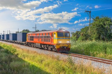 Tren vagonları konteynır lokomotifi demiryolu boyunca güneşli bir günde seyahat eder..