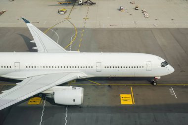 Yüzeydeki havaalanı yol işaretlerinin hava görüntüsü. Uçak terminale gidiyor.