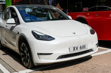 Beyaz Tesla araba modeli şehir caddesinde sürüyor. Çin, Hong Kong, 19 Ocak 2024.