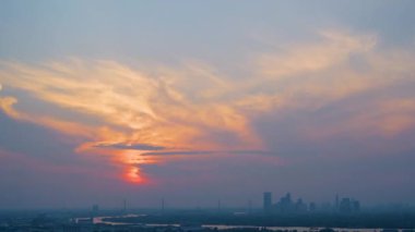 İş bölgesindeki modern ofis binaları üzerinde zaman aşımı aralığı gün batımı. Skyline sirrus bulutlu şehir manzarası disk güneş ışığı ve parlaklığıyla