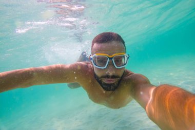 Beyaz erkek şnorkelli adam el değmemiş turkuaz su selfie 'si altında..