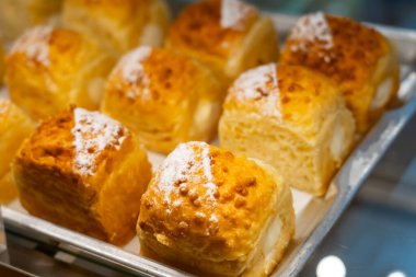 Güzel bir pastane vitrininde pudra şekeri serpilmiş yemyeşil çörekler..