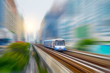 Elektrikli tren vagonu, modern şehir binaları ve gökdelenler arasında gökyüzü yolu viyaolkü boyunca ilerliyor. Modern konforlu hızlı yolcu taşımacılığı kavramı.