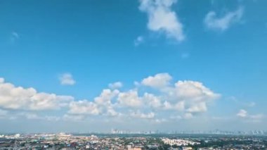 Nehir kıyısındaki şehir gökdelenlerinin üzerinde mavi gökyüzü beyaz bulutlar. Kabarık beyaz bulutlar. Kümülüs bulutlu zaman çizelgesi. Yaz mavisi gökyüzü zaman atlaması döngüsü.
