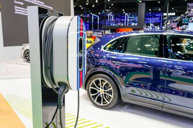 Porsche markalı mavi lüks elektrikli araçta şarj oluyor. Tayland, Bangkok 07 Nisan 2024.