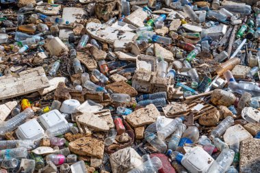 Nehre paralel uzanan büyük çöp yığını - plastik, kauçuk ve diğerleri. Ana ürünler atık petrol ürünleri.