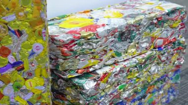 Büyük ve ağır balyalara sıkıştırılmış alüminyum kutular. Geri dönüşüm ve çevreyi ev atıklarından temizlemek. Metal içki kapaklarından çöp metali bloklar oluşturdu. Tayland, Bangkok 15 Nisan 2024.