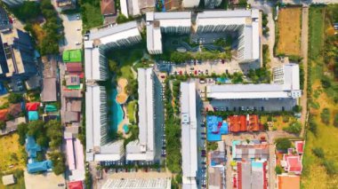 Düşük katlı binalar arasında havuz manzaralı yüzme havuzu kompleksi.