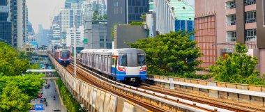 Modern metro elektrikli treni, gökdelenler arasındaki cambaz ayaklıkları üzerinde bir köprü üzerinde dönüş hızı bulanıklığı olan metro.