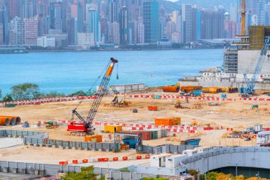 Apartman inşaatı için vakıf çukurunda yığın sürüşü. Kazı araçları, vinçler, buldozerler ve kamyonlar ile derin tesis ve kazı.