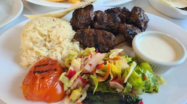 Baharatlı barbekü ziyafeti: Izgara köfte, pirinç, salata ve lezzetli soslar