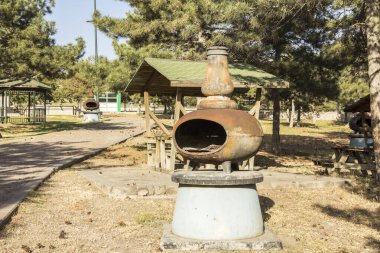 Parkta ahşap kamelya ve yanında ızgara.