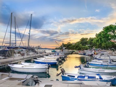 Limanda teknesi olan sakin bir sahil, gün batımı gökyüzü, huzurlu marina - mükemmel bir tatil yeri..