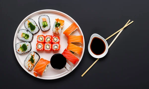 典型的日本菜 全世界的成功 寿司放在黑桌上 顶视图 免版税图库照片
