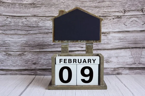 stock image Chalkboard with calendar date on white cube block on wooden table.