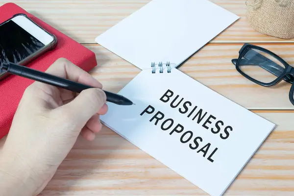 Business proposal text written on notepad on office table. Business concept.