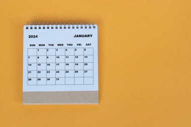 Ocak 2024 sarı arka planda masa takvimi. Tam üstte. Düz yatıyordu. Boşluğu kopyala.