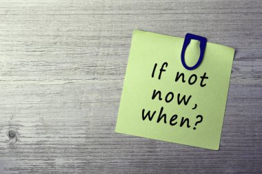 İlham verici alıntılar - Eğer şimdi değilse, sarı çıkartma ile ilgili soru sorulduğunda ahşap masa üzerinde mavi ataç ile.