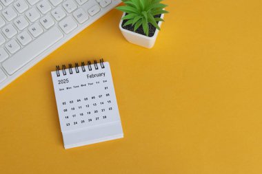 Sarı arka planda Şubat 2025 masa takvimi. Tam üstte. Düz yatıyordu. Boşluğu kopyala.