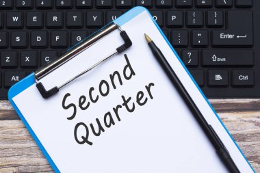 Tahta üzerinde kalem ve klavye bulunan ikinci klavye alıntılayıcı metni olan panonun üst görünümü.