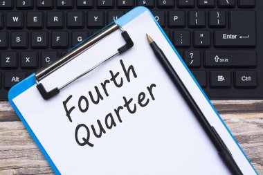 Tahta üzerinde kalem ve klavye bulunan dördüncü kota metni olan panonun üst görünümü.