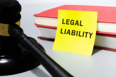 Hakimler, sarı nota yazılı yasal yükümlülükle tokmak ve beyaz arkaplanda kırmızı kitaplar ile.