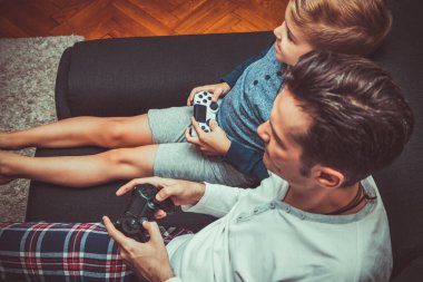 High angle view of happy kid playing video game with his father at home. 
