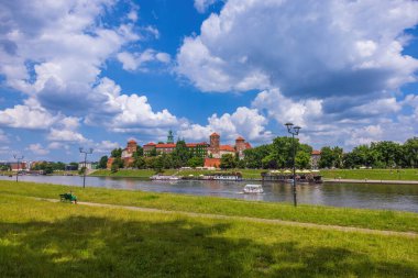 Vistula nehri Wawel Hill 'deki Krakov kraliyet sarayının altından akar ve güneşli bir öğleden sonra geçirir.. 