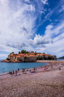 Budva, Karadağ - 15 Eylül 2024: Karadağ 'ın Budva kenti yakınlarındaki güzel Sveti Stefan adası. Mavi Adriyatik Denizi 'ndeki adanın tarihi kırmızı çatılı evleri 