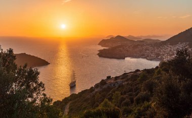 Adriyatik Denizi üzerinde Dubrovnik yakınlarındaki altın gün batımına bakın. Önünde yelkenli yatı olan eski bir kasaba.. 