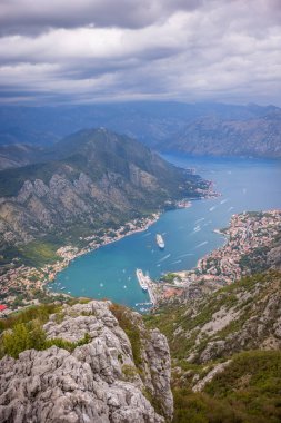 Karadağ 'ın Kotor Körfezi manzarası, virajlı virajlı yüksek bir dağ yolundan. Manzarada Kotor kasabası ve Kotor Körfezi yer almaktadır..