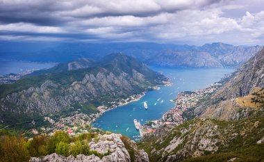 Karadağ 'ın Kotor Körfezi manzarası, virajlı virajlı yüksek bir dağ yolundan. Manzarada Kotor kasabası ve Kotor Körfezi yer almaktadır..