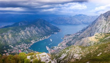 Karadağ 'ın Kotor Körfezi manzarası, virajlı virajlı yüksek bir dağ yolundan. Manzarada Kotor kasabası ve Kotor Körfezi yer almaktadır..