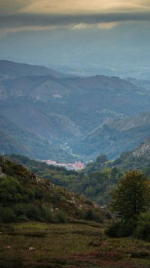 Covadonga ve Picos de Europa dağlarının çarpıcı manzarası. Bazilika, gür ormanlar ve yuvarlanan tepelerin ortasında duruyor. Bölgenin doğal ve kültürel güzelliğini gözler önüne seriyor.