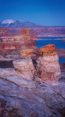 Alstrom Point at sunset offers a stunning view of Lake Powell, surrounded by dramatic red rock formations and layered canyons under a vibrant sky, perfect for outdoor photography. clipart