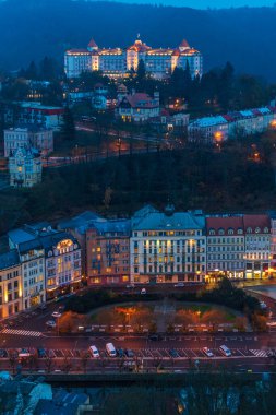 Çek Cumhuriyeti, Karlovy Vary 'nin sonbahar şehri. Renkli binaları, kilise kuleleri, nehir geçidi ve altın sonbahar yeşilliklerindeki ormanlık tepeleri olan tarihi bir spa kasabası..