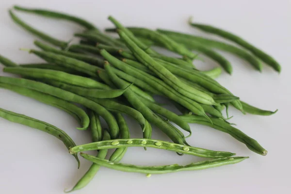 Bunch of French Beans shot on white back ground with few sliced half. It is also called green beans, bush beans, string beans, snap beans, haricot vert. Scientific name is Phaseolus vulgaris.