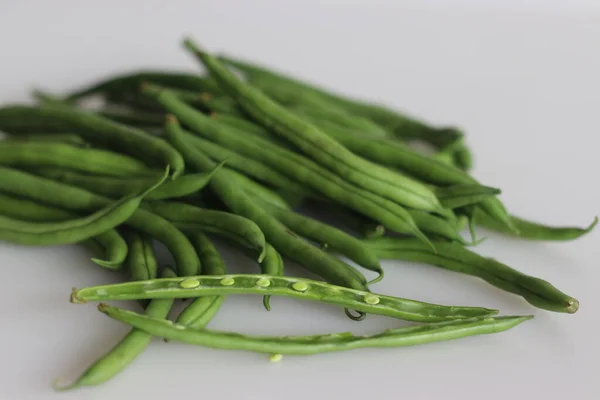 Bunch of French Beans shot on white back ground with few sliced half. It is also called green beans, bush beans, string beans, snap beans, haricot vert. Scientific name is Phaseolus vulgaris.