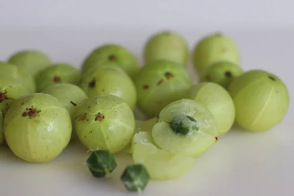 Amla or Indian Gooseberries are small, nutritious fruits produced from gooseberry tree. It has culinary and herbal medicine uses. Shot on white background along with split gooseberry and its seeds