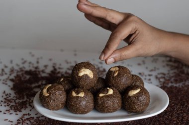 Poongar rice laddu. Sağlıklı bir aperatif ya da vajina pilavı, jaggery ve taze rendelenmiş hindistan cevizinden yapılmış ladoo. İçinde kahve, yağ ve şeker olmayan bir tarif. Arka planda vajina pilavı ile vurulmuş..