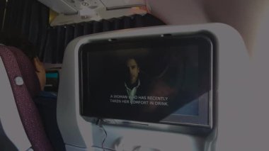 Mumbai, Hindistan, Nisan 2023: Hintli bir yerli havayolu şirketi olan Vistara Air 'in arka koltuğunda sabitlenmiş TV ekranını kullanarak Inlight Entertainment üzerinden altyazılı film izlemek