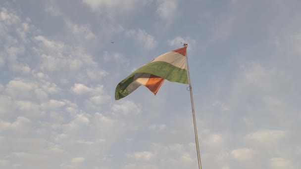 印度三色旗高高地升起 在晨风中飘扬 同时一架在后方飞行的飞机在空中盘旋 — 图库视频影像
