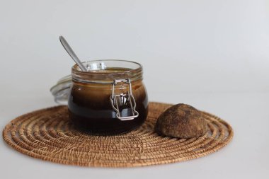 Ev yapımı avuç içi jaggery şurubu. Katı palmiye tırtıklı ısıtma bloğundan yapılan sıvı palmiye tırpanı. Kahve ve çöl için sağlıklı tatlandırıcı. Beyaz arkaplanda çekilen.