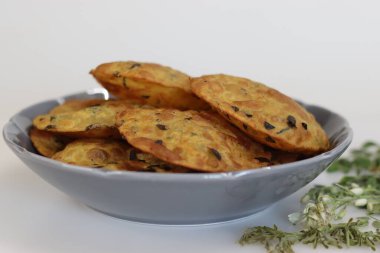 Moringa yapraklı Daal Poori. Kızarmış Hint ekmeği tam buğday unundan, pişirilmiş mercimek, moringa yaprağı ve baharattan. Beyaz arkaplanda çekilen.