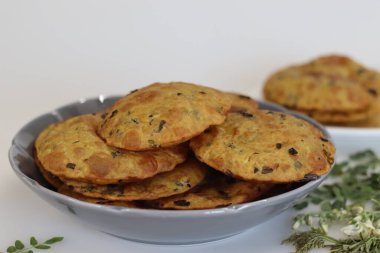 Moringa yapraklı Daal Poori. Kızarmış Hint ekmeği tam buğday unundan, pişirilmiş mercimek, moringa yaprağı ve baharattan. Beyaz arkaplanda çekilen.