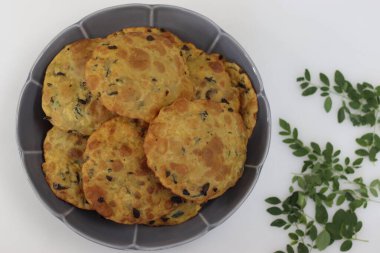 Moringa yapraklı Daal Poori. Kızarmış Hint ekmeği tam buğday unundan, pişirilmiş mercimek, moringa yaprağı ve baharattan. Beyaz arkaplanda çekilen.